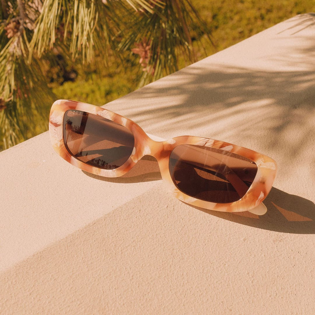 Daphne by DIFF Polarized Sunglasses Resting on Outdoor Table