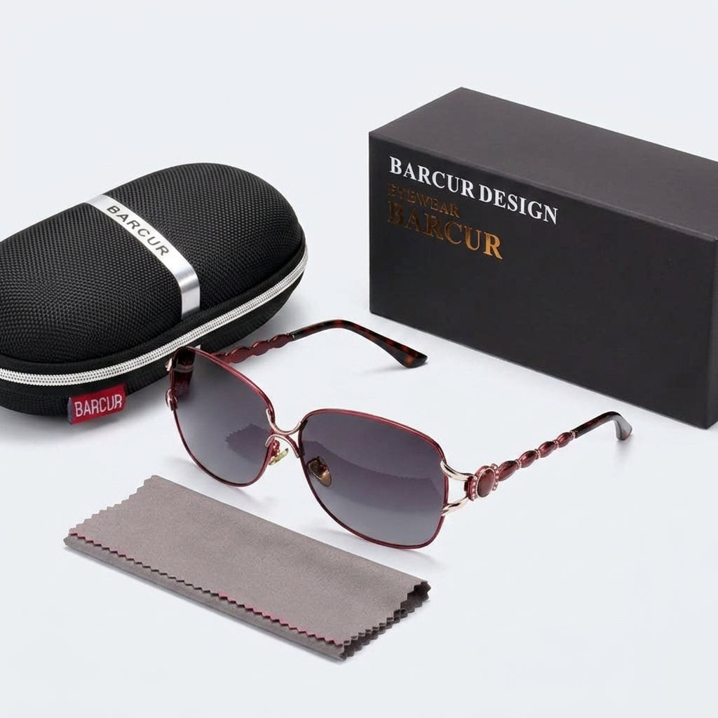 Flat lay of women's sunglasses with hard zippered case, gift box, and microfiber cloth